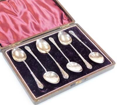 A set of six Edwardian silver teaspoons, each with entwined stems and shaped ends, with plain bowls, Birmingham 1910, 10cm wide, in fitted case. (6)