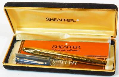 A Sheaffer fountain pen, with 585 nib, in gilt colours, textured with shortened clip, 13cm wide, in fitted case.