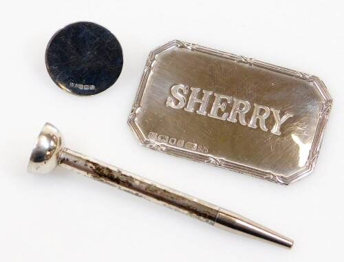 A sterling silver golf tee and ball marker, the tee 6cm high, and Elizabeth II sherry label with canted corners. (2)