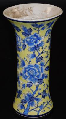 A Chinese porcelain beaker vase, decorated with flowers in blue on a yellow ground, 34cm high.