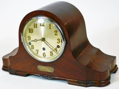 An early 20thC walnut cased Napoleon hat mantel clock, in shaped case with 14cm diameter Arabic dial revealing a chiming movement on nine various bells, set with a plaque dated 1937, with key, 26cm high, 44cm wide, 17cm deep.