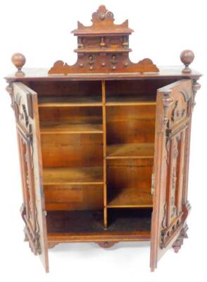 A late 19thC continental oak hanging cupboard, with raised carved panelled doors with a carved top, 59cm high, 44cm wide, 18cm deep. (AF) - 3
