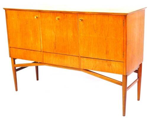A vintage teak Meredew sideboard, of rectangular form, with three cupboards on turned legs joined by shaped front to back stretchers, 94cm high, 141cm wide, 48cm deep.