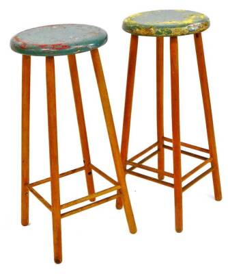 A pair of vintage elm stools, each with painted circular tops on quadruple legs joined by double turned stretchers, 71cm high, 29cm diameter. (2)