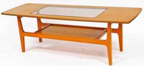 A retro teak coffee table, of oblong form, with glass insert raised on shaped legs joined by an under tier, 44cm high, 137cm wide, 49cm deep.