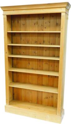 A pine freestanding open bookcase, with fixed cornice above open removable shelves flanked by fluted columns on a block base, 199cm high, 117cm wide, 35cm deep.