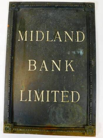 A vintage Midland Bank Limited metal sign, in black with white lettering and raised border with floral spandrels, 45cm high, 31cm wide, 3cm deep.