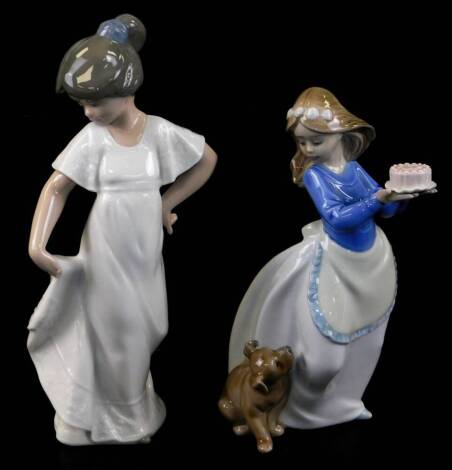 Two Nao figures, comprising a girl in flowing robes, 23cm high, and another holding cake aside puppy, printed marks beneath. (2)