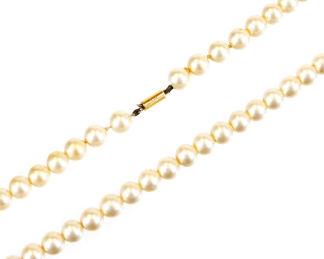 A synthetic pearl necklace, with cylindrical claps, marked 9ct, 36cm long.