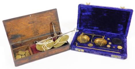 An early 19thC oak cased set of brass apothecary or gold weights and pan balance, and a further modern set. (2)