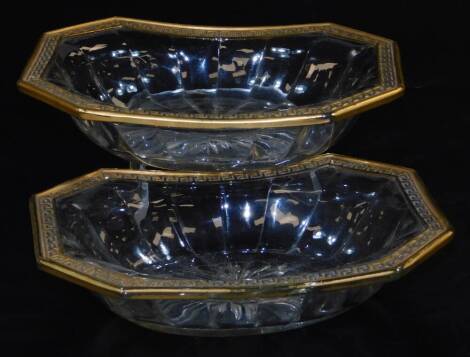 A pair of early 20thC Hermes style glass dishes, each of octagonal form, with an outer gilt Greek key decoration, with a raised star burst centre to each, unmarked, 21cm wide.