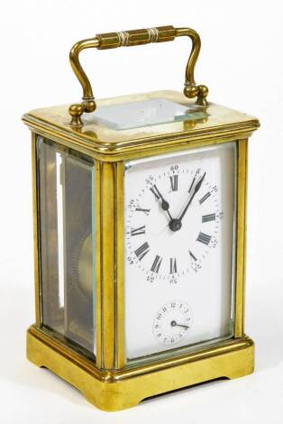 An early 20thC brass carriage clock, of rectangular form, with a five sectional glass case and swing handle, with 5cm wide Roman numeric dial and subsidiary Arabic second hand, with an open keywind movement, striking on a bell, with plain back plate numbe