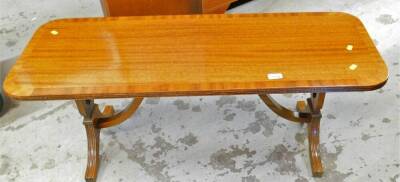 A mahogany coffee table, of oblong form with a wide crossbanding on lion's capped feet, 43cm high, 107cm wide, 40cm deep.