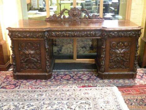 A Victorian carved oak pedestal sideboard