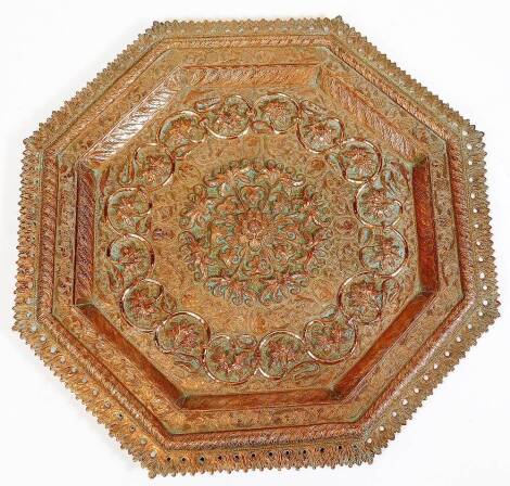 A late 19thC Indian or Burmese octagonal copper plaque, with pierced and raised border, the centre with raised central foliate medallion within a border of engraved figural medallions and raised leaf border, 41.5cm diameter.