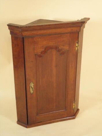 An 18thC oak corner cabinet with moulded corners