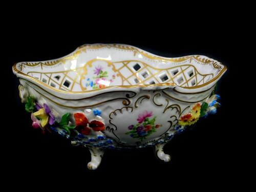 A 20thC Dresden porcelain bowl, of pierced form, encrusted and painted with flowers, raised on four leaf scroll feet, printed and impressed marks, 18cm diameter.