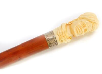 A Victorian malacca walking stick, with an ivory handle carved with an African gentleman, dated verso December 6th 1865, with white metal ferrule, 104.5cm high.