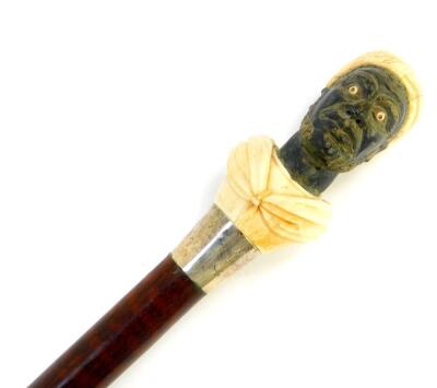 A snake wood walking stick, with an ebony and ivory carved figural handle of a Moor, white metal ferrule and ivory tip, 97.5cm high.