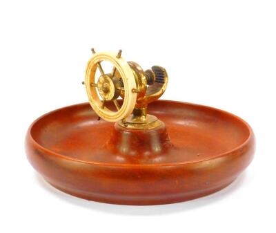 A 20thC teak nut bowl, with brass and white plastic ship's wheel nutcracker, 23cm diameter.