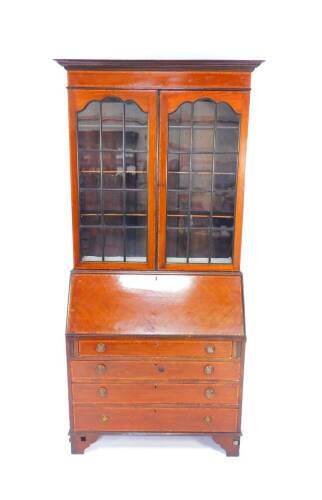 An Edwardian mahogany and satinwood cross banded bureau bookcase, the outswept pediment over base doors, opening to reveal three shelves, above a fall flap, opening to reveal drawers and recesses, above four long graduated drawers, raised on bracket feet,