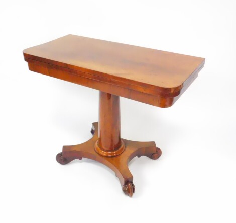 A Regency rosewood foldover card table, with beige interior, raised on a cylindrical column, over a quatrefoil base, on scroll feet, 91.5cm wide, 44.5cm deep, 75cm high.