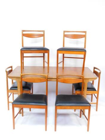 A Mackintosh teak double leaf extending dining table, raised on turned legs, 158cm wide, 234cm extended, 92cm deep, 73.5cm high, together with six single dining chairs, model number 9433, with black leatherette seats.