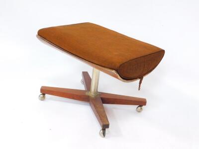 A G-Plan teak and red walnut stool, with a loose brown fabric cushion, raised on a metal column and X framed base, on castors, 60cm wide.