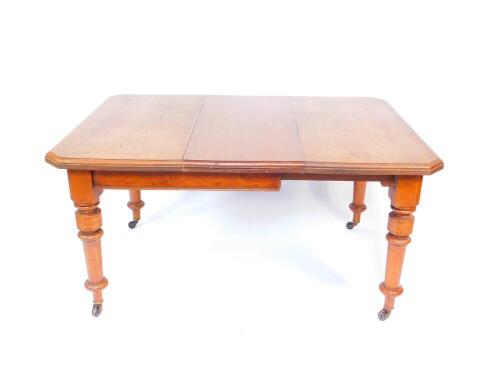 A Victorian mahogany wind out dining table, with one additional leaf, on turned legs, brass capped on castors, 106cm wide, 151cm extended, 106cm deep, 75cm high.