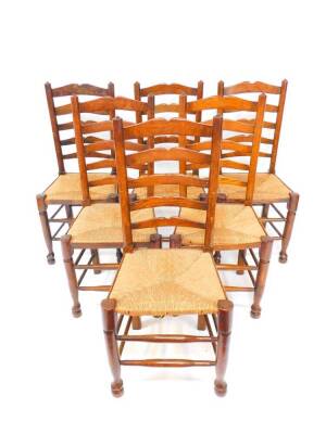 A set of six 19thC oak single ladderback dining chairs, with rush seats, raised on turned legs, united by stretchers.