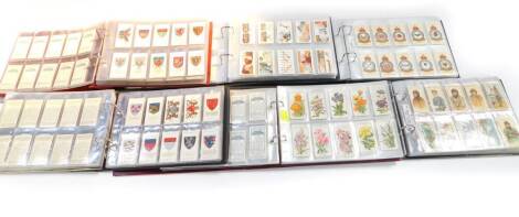 Five albums of cigarette cards, chiefly part sets, including Wills's Engineering Wonders, Romance of The Heavens, and Overseas Dominions (Canada), John Player Flags of The League of Nations, Natural History and History of The Naval Dress.