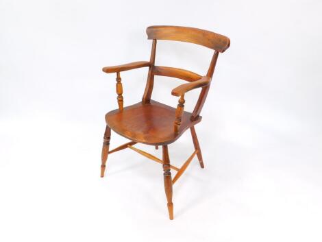 A Regency oak and elm country carver chair, with saddle seat, raised on turned legs, united by an H framed stretcher.