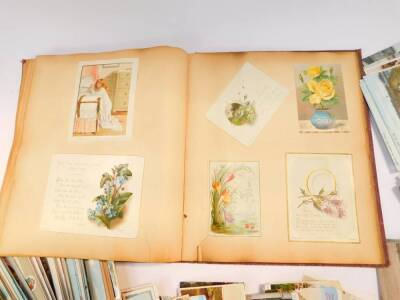 Edwardian and later topographical postcards and greetings cards, together with a Victorian scrap book. (quantity) - 3