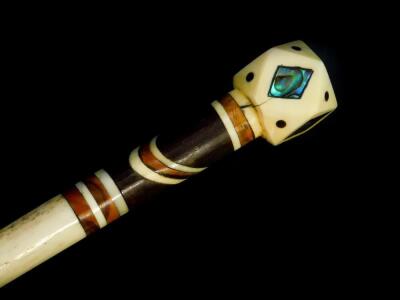 A 19thC whale bone and baleen inlaid walking cane, the faceted rhomboid handle with mother of pearl inlay, 82.5cm high.