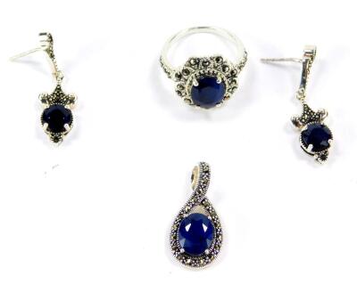 A silver sapphire and marcasite ring, 29.5cts, size N/O, together with a sapphire and marcasite pendant and pair of earrings, with certificates.