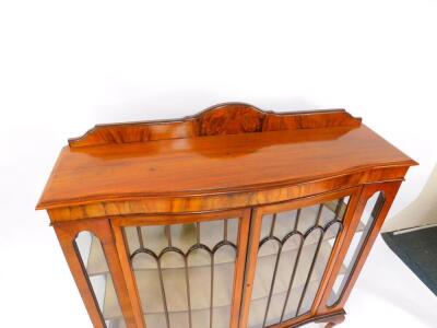 An early 20thC serpentine walnut display cabinet, with a pair of glazed doors opening to reveal two shaped shelves, glazed sides, raised on cabriole legs and ball and claw feet, 136cm high, 121cm wide, 37cm deep. - 2