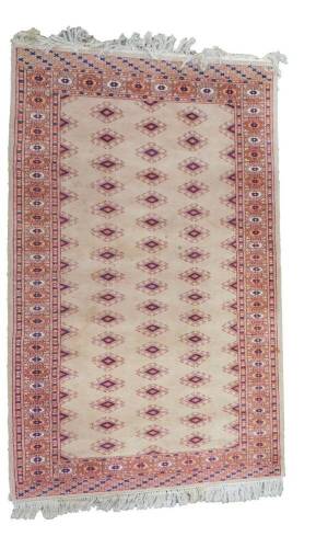 A Turkoman wool rug, decorated with repeating guls against a pale brown ground, 164cm x 96cm.