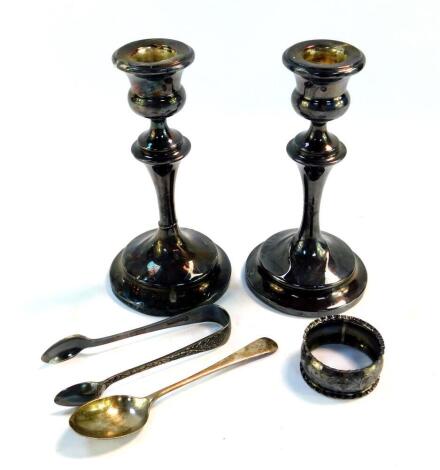 A pair of George V loaded silver candlesticks, Chester 1927, 14.13oz all in, 15.5cm high, together with a silver tea scoop spoon, Birmingham 1928, and an Edward VII silver napkin ring, Chester 1904, 0.73oz., and a pair of plated sugar tongs.