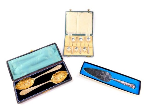 A set of George VI silver coffee spoons, Sheffield 1944, cased, 2.85oz., silver handled Kings pattern cake slice, boxed., and a pair of Victorian silver and gilt plated berry spoons, cased.