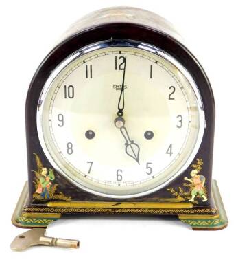 A Smiths Enfield brown Bakelite and japanned lacquered mantel clock, silvered dial bearing Arabic numerals, eight day movement with coil strike, the case decorated with Oriental figures, and a phoenix, with pendulum, with key, 22cm wide.