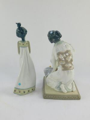 A Lladro porcelain figure modelled as a Oriental girl, 0840, and another of a girl holding a kitten in her arms, both boxed. (2) - 3