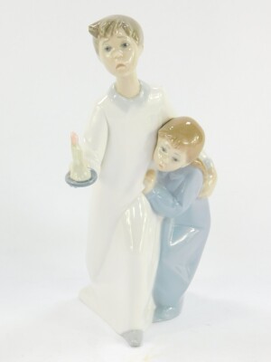 A Lladro porcelain figure modelled as Magical Moment, 06171, boxed, together with a Lladro figure group of a boy and girl in night attire, with a chamber stick, and a further Lladro figure of a kneeling girl. (3) - 2