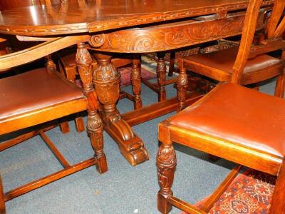 A Continental early 20thC oak dining room suite, stylistically carved with flowers and scrolling leaves, comprising a serpentine wardrobe, with carved splash back, having four doors enclosing drawers, shelves and a bottle stand, raised on a shaped base, 1 - 4