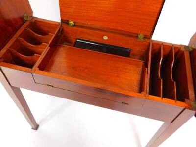 An Edwardian mahogany 'Britisher' writing table, of canted rectangular form, the central hinged section opening to reveal a fitted interior, with two hinged side flaps, raised on tapering square legs, 76cm high, 91cm wide, 44.5cm deep. - 4