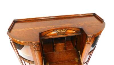 A Continental early 20thC oak bureau cabinet, carved with flowers, the central fall flap opening to reveal drawers and recesses, over a pair of bow fronted cupboard doors, flanked by two glazed doors, opening to reveal six shelves, raised on a plinth base - 3