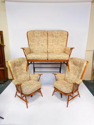 A vintage Ercol light oak three piece cottage suite, upholstered in floral fabric cushions, comprising two seater sofa, 141cm wide, and a pair of armchairs. - 2