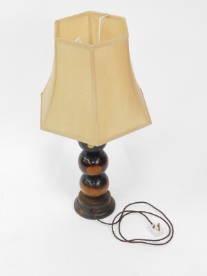 A wooden table lamp, formed as four lignum vitae bowls raised on an oak circular base, with shade, 83cm high.