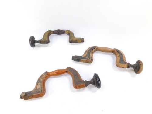 Three carpenter's button pad drill braces, one 19thC in brass and rosewood, signed W Kent, Sheffield, and two beech braces with brass furniture. (5)