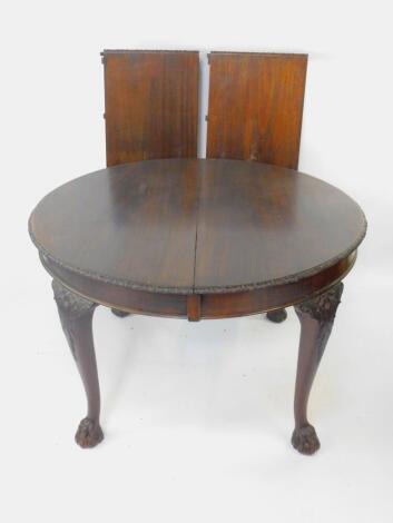 An Edwardian Chippendale style mahogany wind-out dining table, with two additional leaves, raised on leaf carved cabriole legs and ball and claw feet, 76cm H, 122cm W, 211cm extended, 123cm D.