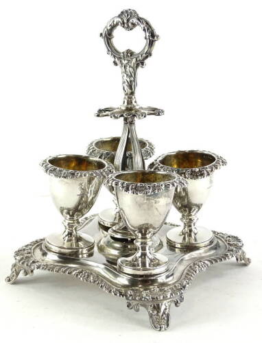 A William IV silver egg cup stand, of quatrefoil shape with recesses for spoons, scroll handle and flower and gadrooned border, housing four removable egg cups, on tapering feet, inscribed to underside "The gift of his mother to her dear son John Hodgson